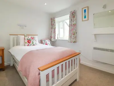 a bedroom with a bed and a window at Bray Cottage in Bodmin