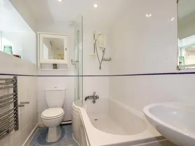 a white bathroom with a toilet and a sink at Bray Cottage in Bodmin