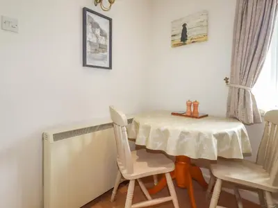 a table and two chairs and a table and a table and chairs at Bray Cottage in Bodmin