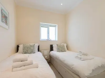 two beds in a small room with a window at Seaspray in St Ives