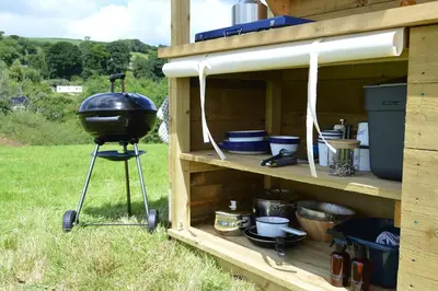 a grill on a stand in a wooden shed at Tylda Tents at Heydaze Campsite - 5m Luxury Bell Tent 