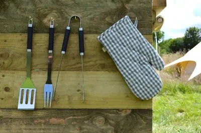 a wooden wall with utensils hanging on it at Tylda Tents at Heydaze Campsite - 5m Luxury Bell Tent 