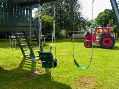 a swing in a yard with a toy car at Penny's Cottage-Uk12572 in Bodinnick