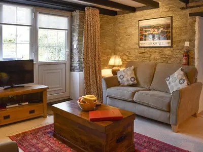a living room with a couch and a tv at The Linney-Uk12576 in Bodinnick