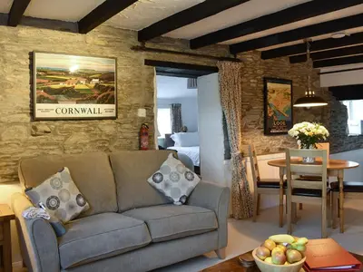 a living room with a couch and a dining room at The Linney-Uk12576 in Bodinnick