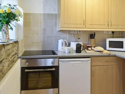 a kitchen with a stove and a dishwasher at The Linney-Uk12576 in Bodinnick