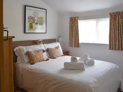 a bedroom with a white bed with towels on it at The Linney-Uk12576 in Bodinnick