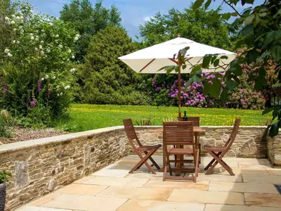 a table and two chairs with an umbrella at The Linney-Uk12576 in Bodinnick