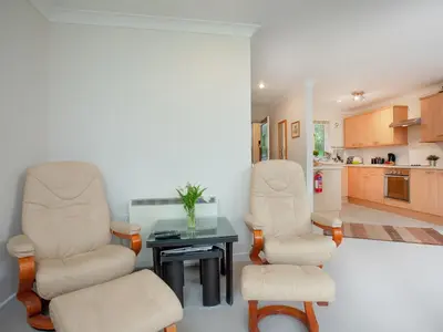 a living room with two chairs and a table at Gull Cottage in Falmouth