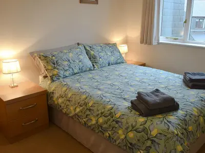 a bedroom with a bed with a bag on it at Gull Cottage in Falmouth