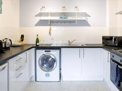 a kitchen with a washing machine and a sink at April Cottage in Padstow