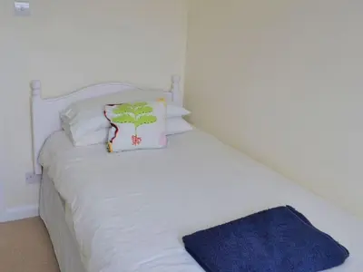 a white bed with a pillow on top of it at Harbourside in Fowey