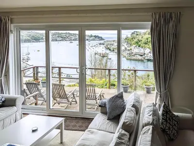 a living room with a couch and a view of the water at Harbourside in Fowey