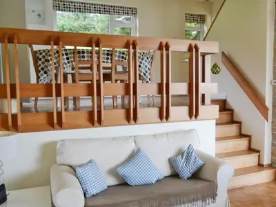 a living room with a couch and a wooden staircase at Harbourside in Fowey