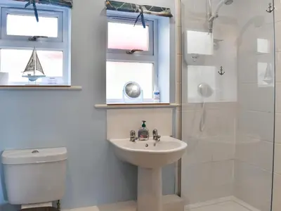 a bathroom with a sink and a shower and a toilet at 15 Pebble Cottage in Camelford