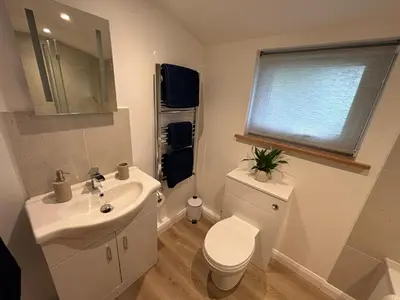 a white bathroom with a sink and a toilet at The Stables at Hustyn Gate in Wadebridge