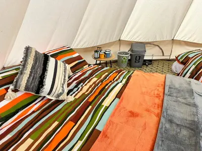 a bed in a tent with two pillows on it at Lakeside Glamping Kingfisher in Saint Columb Major