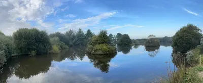 a river with trees in the middle of it at Lakeside Glamping Firecrest in Saint Columb Major