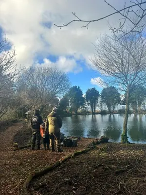 a group of people standing near a river at Lakeside Glamping Firecrest in Saint Columb Major