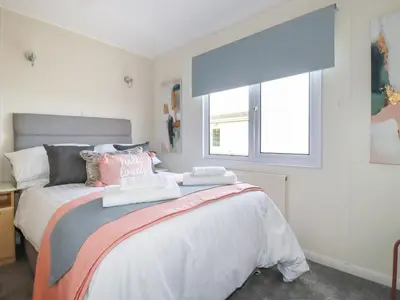 a bedroom with a bed with two towels on it at Lowen Lodge in Padstow