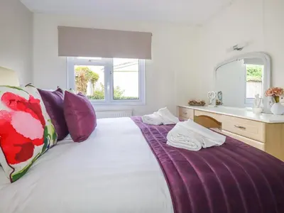 a bedroom with a large bed with a vanity and a sink at Lowen Lodge in Padstow