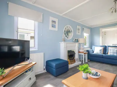a living room with a couch and a tv at Lowen Lodge in Padstow