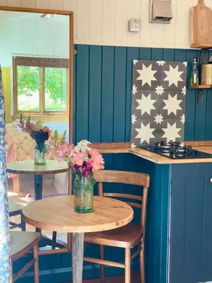 a room with two tables with flowers on it at The Garden Room - Cabin on The Lizard in Cury