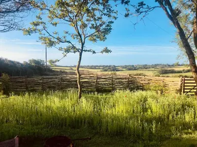 a wooden fence in the middle of a field at The Field Room - Hut on The Lizard in Helston