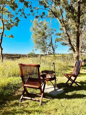 two benches and a picnic table in a field at The Field Room - Hut on The Lizard in Helston