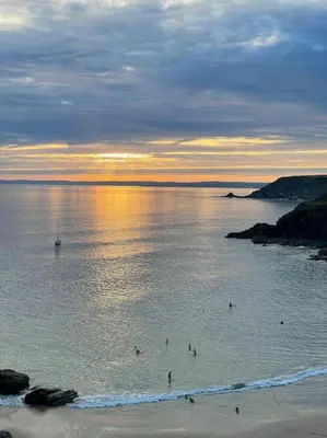 a group of people in the water at the beach at The Field Room - Hut on The Lizard in Helston