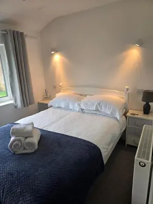 a bedroom with a bed with two towels on it at Seven Bays in Newquay