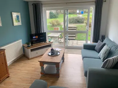 a living room with a blue couch and a coffee table at Seven Bays in Newquay