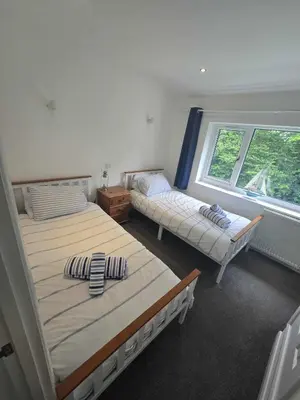 two beds in a room with two windows at Seven Bays in Newquay