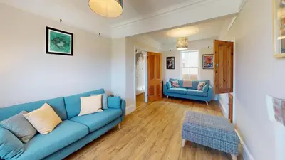a living room with a blue couch and a table at St Ives Bubblegum Cottage in St Ives