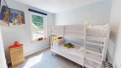 a white bunk bed in a room with a window at St Ives Bubblegum Cottage in St Ives