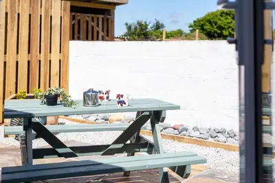 a blue picnic table with figurines on top of it at The Tractor Shed, a romantic barn retreat on the edge of Falmouth in Budock Water