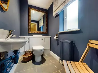 a bathroom with a sink and a toilet and a mirror at Cornwall Truro Falmouth cottage in Perranwell