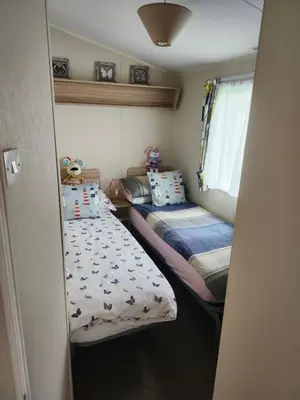 a small bedroom with two beds and a window at Chapmans Holiday Home Newquay in Newquay