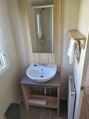 a bathroom with a sink and a mirror at Chapmans Holiday Home Newquay in Newquay
