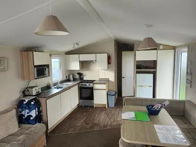 a kitchen and living room with a couch and a table at Chapmans Holiday Home Newquay in Newquay