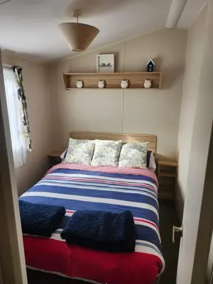 a bedroom with a bed with blue and red at Chapmans Holiday Home Newquay in Newquay