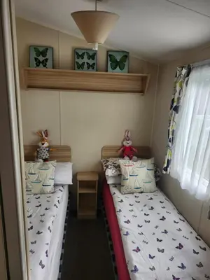 two twin beds in a small room at Chapmans Holiday Home Newquay in Newquay