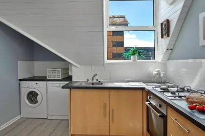 a kitchen with a sink and a washing machine at Finest Retreats - No 11 Porthminster in St Ives