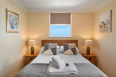 a bedroom with a bed with two lamps and a window at Finest Retreats - No 11 Porthminster in St Ives