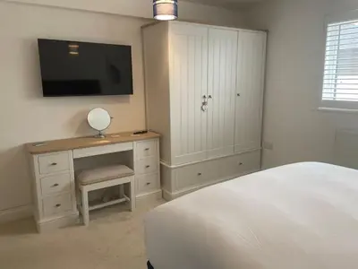 a bedroom with a bed and a desk with a tv at 30 Bredon Court at Fistral Beach Newquay in Newquay