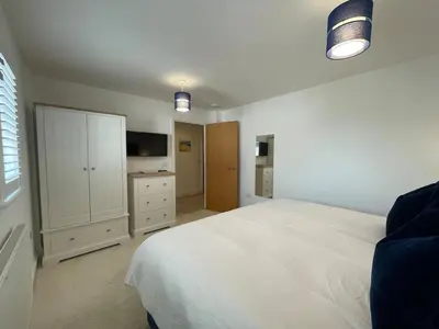 a bedroom with a white bed and a tv at 30 Bredon Court at Fistral Beach Newquay in Newquay