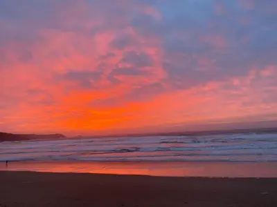 a sunset on a beach with the ocean at 30 Bredon Court at Fistral Beach Newquay in Newquay