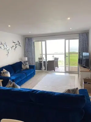 a living room with a blue couch and a television at 30 Bredon Court at Fistral Beach Newquay in Newquay