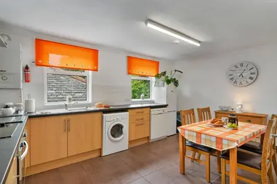 a kitchen with a table and a washing machine at Finest Retreats - Number 10 Porthmeor in St Ives