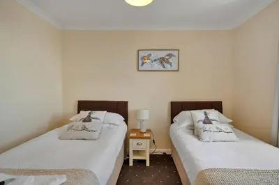 two twin beds in a room with a table at Finest Retreats - Number 10 Porthmeor in St Ives